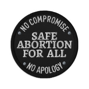 Könnte beinhalten: Schwarzer und weißer gestickter Aufnäher mit dem Text "No Compromise Safe Abortion For All No Apology".