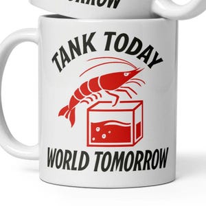 May include: White ceramic mug with black text that reads "Tank Today World Tomorrow". A red shrimp is pictured in a red tank with water.