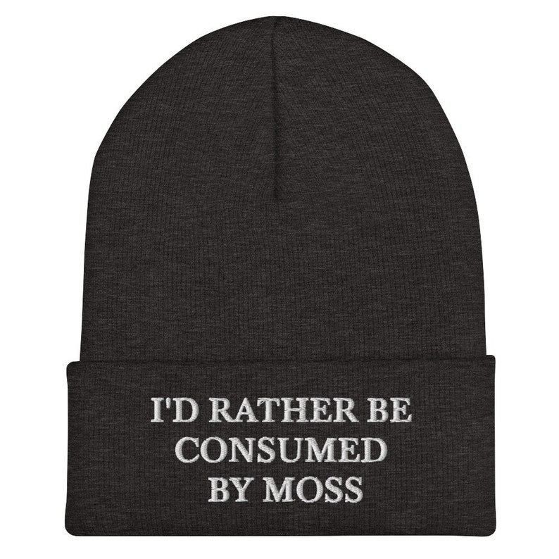 May include: A dark gray beanie with the text "I'd rather be consumed by moss" embroidered in white.
