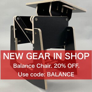Puede incluir: Una silla de equilibrio negra y de madera natural con asiento y respaldo texturizados negros. La silla tiene un dise&ntilde;o &uacute;nico con m&uacute;ltiples articulaciones giratorias. El texto "NEW GEAR IN SHOP" se muestra en un rect&aacute;ngulo rojo.