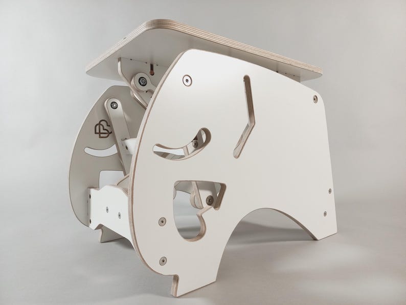 Puede incluir: Un escritorio de pie blanco y ajustable hecho de madera. El escritorio tiene una parte superior rectangular y un dise&ntilde;o &uacute;nico recortado en los lados. La altura del escritorio es ajustable y tiene una base resistente. El escritorio est&aacute; dise&ntilde;ado para uso ergon&oacute;mico.