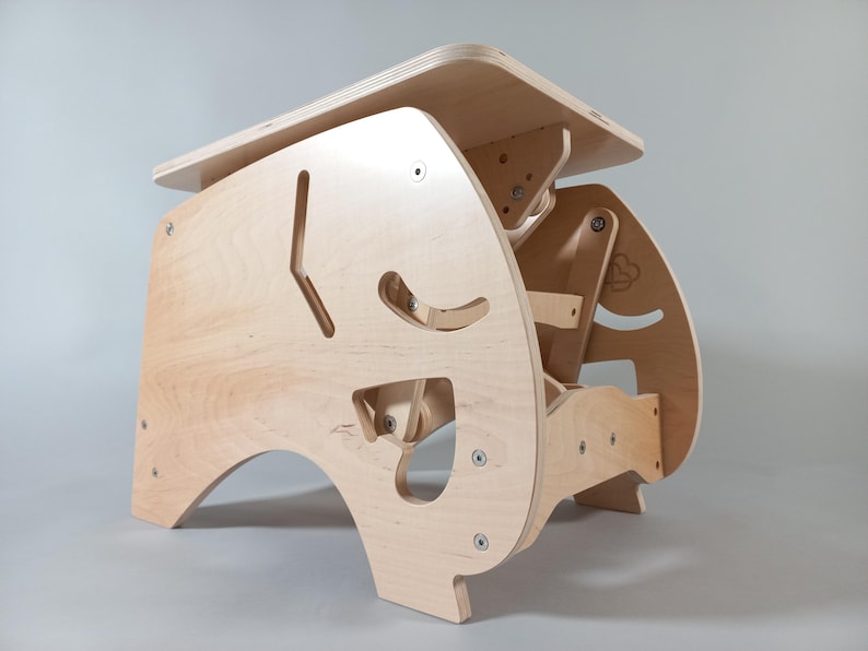 Puede incluir: Un escritorio infantil de madera clara con un dise&ntilde;o geom&eacute;trico &uacute;nico. El escritorio presenta formas recortadas y una peque&ntilde;a mesa rectangular. El escritorio est&aacute; hecho de madera contrachapada y tiene tornillos visibles.