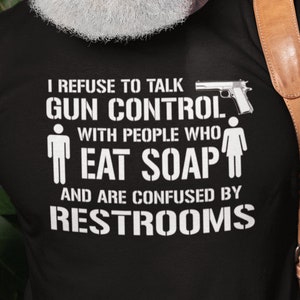 Könnte beinhalten: Schwarzes T-Shirt mit einem weißen Aufdruck, der lautet: "Ich weigere mich, mit Leuten über Waffengewalt zu sprechen, die Seife essen und mit Toiletten überfordert sind."
