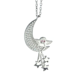 May include: A silver-toned pendant necklace featuring a crescent moon encrusted with small, clear stones. An angel figure with red eyes and wings is nestled within the moon, with three dangling stars below. The chain is also silver.