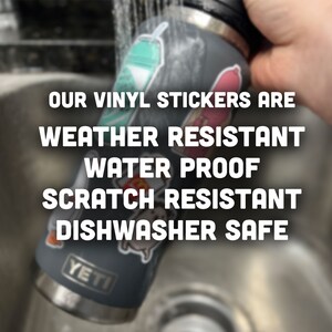 May include: A gray Yeti water bottle with various vinyl stickers on it. The bottle is being rinsed under a faucet. The text "OUR VINYL STICKERS ARE WEATHER RESISTANT WATER PROOF SCRATCH RESISTANT DISHWASHER SAFE" is displayed on the image.