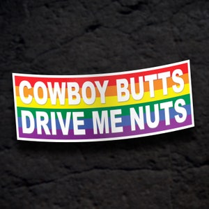 May include: A rainbow-colored sticker with the text "COWBOY BUTTS DRIVE ME NUTS" in white letters.