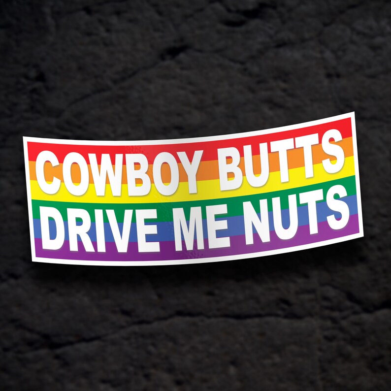 May include: A rainbow-colored sticker with the text "COWBOY BUTTS DRIVE ME NUTS" in white letters.