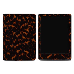 May include: Tortoiseshell-patterned e-reader and matching cover. The cover features a repeating pattern of dark brown and tan spots. The e-reader has a black screen and a tortoiseshell-patterned frame. The design is reminiscent of natural tortoiseshell.