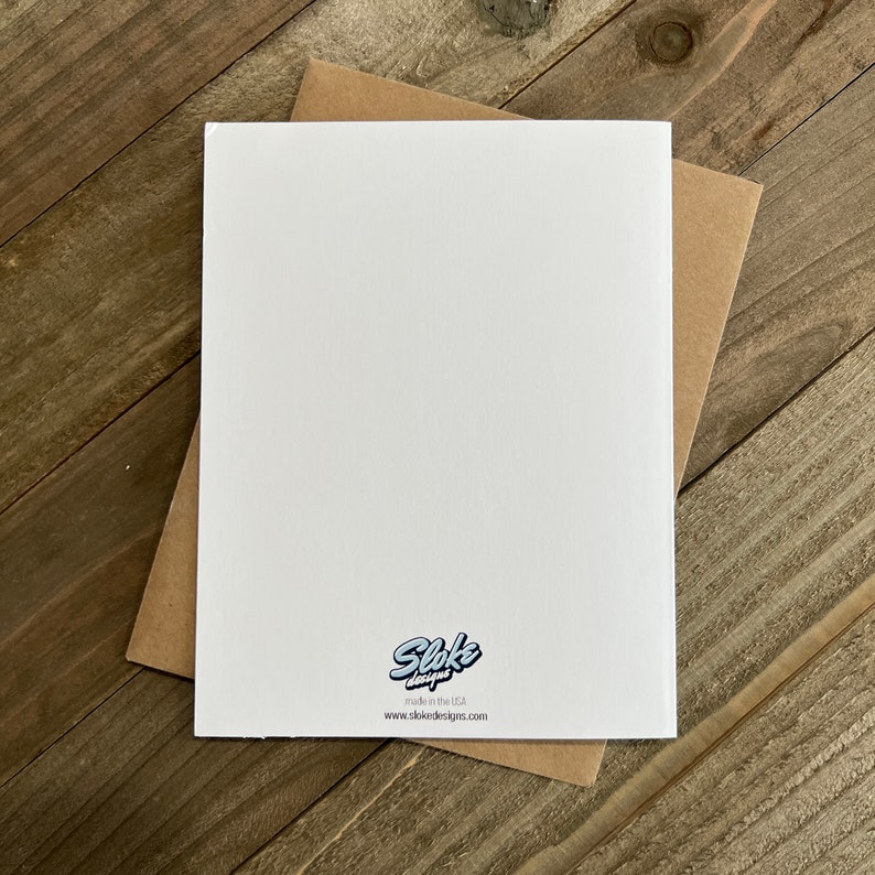 May include: Blank white card with a brown envelope. The card has a small logo in the bottom right corner that says "Sloke Designs" and "made in the USA" with the website "www.slokedesigns.com" below the logo.