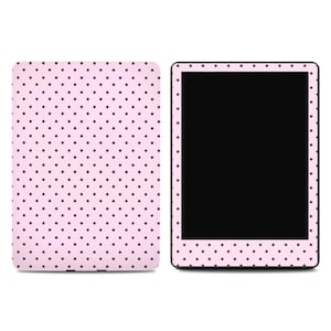 May include: A pink tablet and cover with a repeating pattern of small, dark purple polka dots. The tablet screen is black. The cover is rectangular and has the same polka dot pattern.