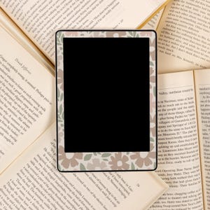 May include: A digital photo frame with a floral pattern border. The frame is black and has a white background. The floral pattern is in shades of brown, pink, and green.