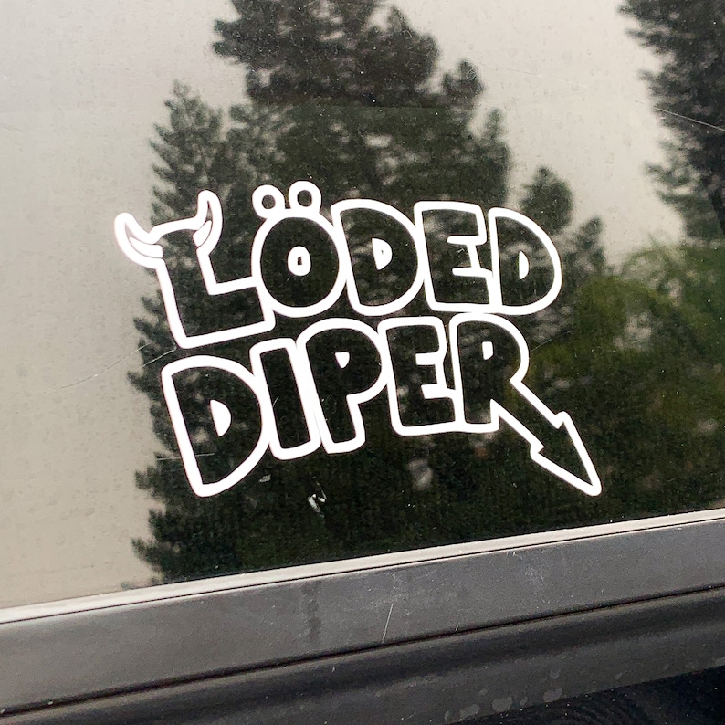 May include: White vinyl sticker on a car window with the text "L&Ouml;DED DIPER" in a bold, cartoon-like font. The sticker features a small cartoon bull's head with horns.