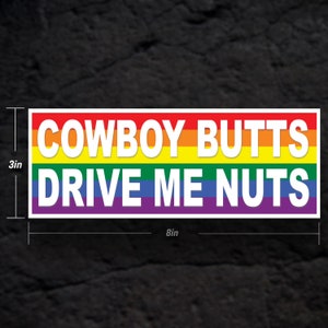May include: A white sticker with rainbow stripes and the text "COWBOY BUTTS DRIVE ME NUTS". The sticker is 8 inches wide and 3 inches tall.