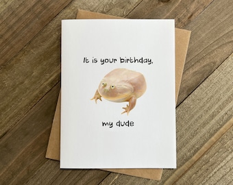 May include: A white birthday card with a cartoon frog and the text "It is your birthday, my dude".