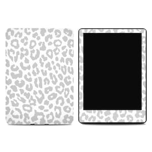 May include: A white tablet and cover with a gray leopard print pattern. The tablet has a black screen and a matching leopard print border. The cover is also white with the same gray leopard spots.