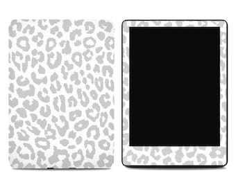 May include: A white tablet and cover with a gray leopard print pattern. The tablet has a black screen and a matching leopard print border. The cover is also white with the same gray leopard spots.