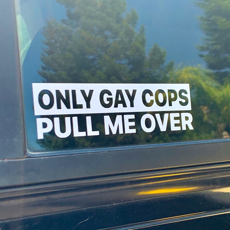 Puede incluir: Una pegatina blanca en la ventana de un coche negro que dice "ONLY GAY COPS PULL ME OVER".