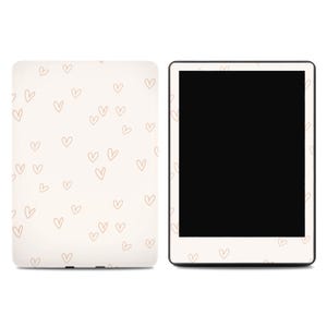 May include: A cream-colored tablet case and tablet with a black screen. The case is covered in small, light brown heart outlines. The tablet has a black screen and a white border with heart outlines.