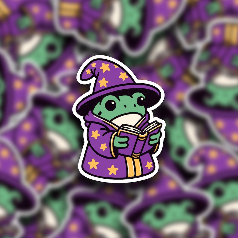 May include: A green frog wearing a purple wizard hat with yellow stars and a purple robe, holding a closed purple book.