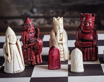 Könnte beinhalten: Ein Schachspiel mit Holzfiguren, die in Rot und Weiß bemalt sind, auf einem schwarz-weißen Schachbrett. Die Figuren umfassen König, Dame, Läufer, Springer und Bauer.