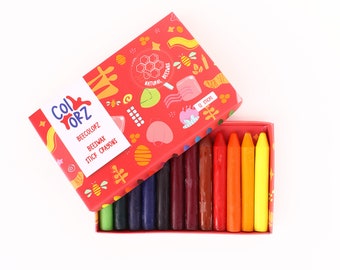 Puede incluir: Una caja de 12 crayones de cera de abeja en una variedad de colores, incluyendo verde, azul, morado, rojo, naranja y amarillo. La caja es roja con un diseño de abeja y panal y el texto "Beecolorz Beeswax Stick Crayons" y "12 Sticks".
