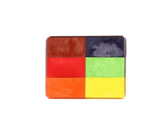 Puede incluir: Seis bloques rectangulares de crayones de cera en diferentes colores: marrón, rojo, naranja, azul oscuro, verde y amarillo.
