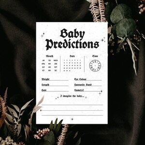 May include: A printable baby predictions card with a black and white gothic font. The card has a calendar, a clock, and spaces to write in the baby's weight, length, hair color, eye color, favorite band, and name. The text on the card reads "Baby Predictions".