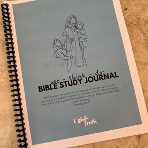 May include: A spiral-bound Bible Study Journal with a light blue cover. The cover features a line drawing of a religious figure with two children and the text "see - think - do: BIBLE STUDY JOURNAL". The journal also includes a quote from 1 Timothy 4:12-13.