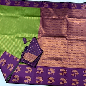 May include: A vibrant green and purple saree with a matching blouse. The saree features a striped green field, a patterned purple border with gold floral motifs, and a rich purple and gold patterned section. The blouse is a deep purple with gold accents.