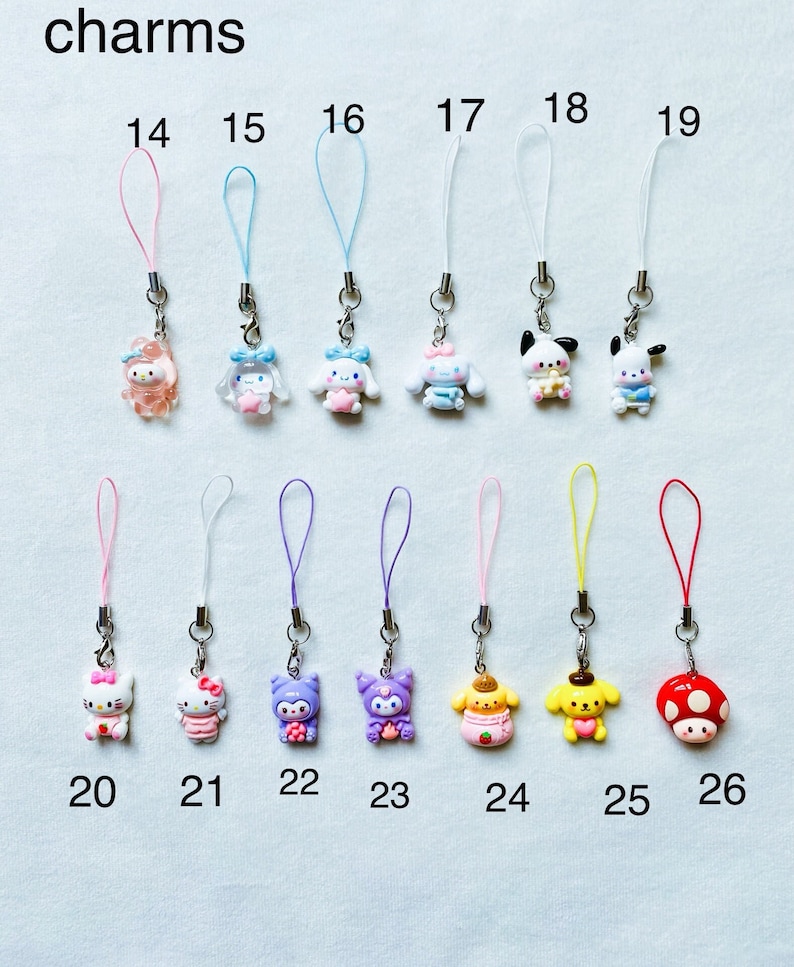 Pode incluir: Um conjunto de 12 pingentes de telefone coloridos com v&aacute;rios personagens de desenhos animados, incluindo Hello Kitty, My Melody e Pochacco. Os pingentes s&atilde;o presos a cordas coloridas e numerados de 14 a 26.
