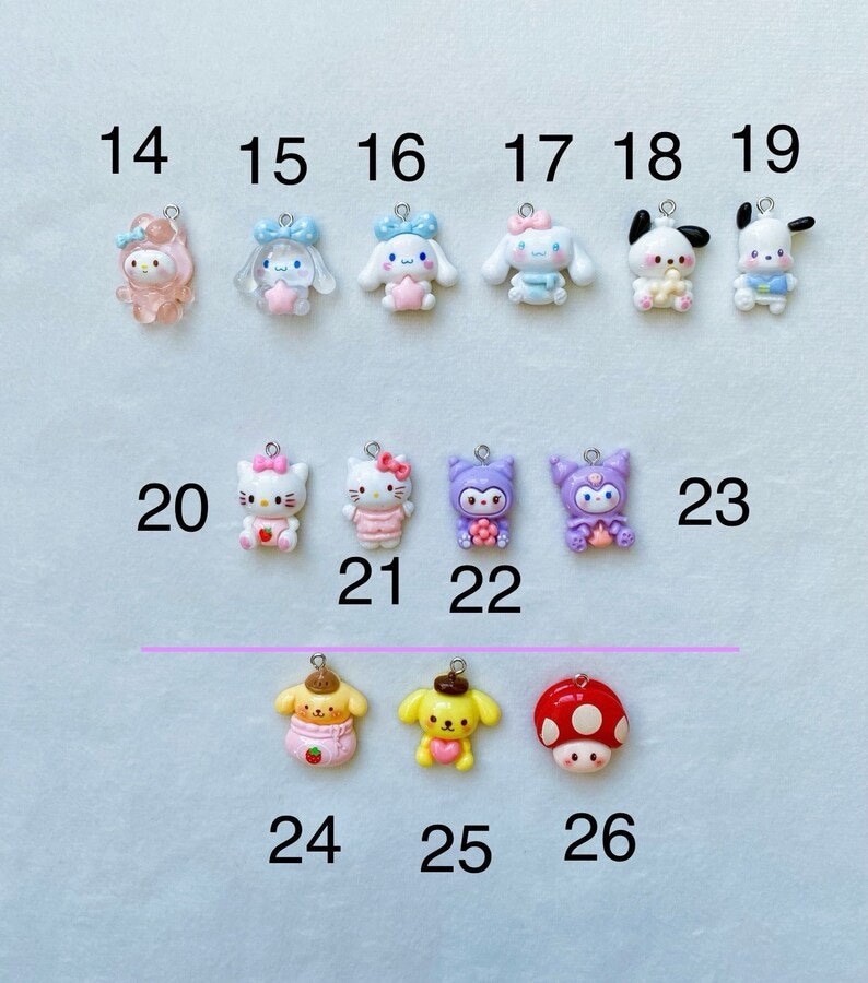 May include: A collection of 26 colourful charm pendants featuring various cartoon characters, including Hello Kitty, My Melody, and Pompompurin. The charms are made of polymer clay and have a variety of colours and designs.