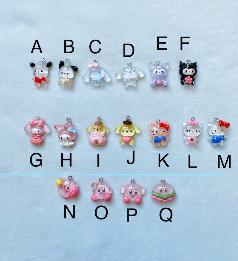 May include: A set of 17 clear resin charms featuring various cartoon characters, including Hello Kitty, My Melody, and a dog with a strawberry. The charms are labelled with letters A through Q.