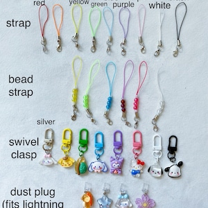 Pode incluir: Conjunto de pingentes de telefone coloridos com diferentes designs. Os pingentes incluem uma variedade de cores, como vermelho, laranja, amarelo, verde, azul, roxo, rosa, branco e preto. Os pingentes s&atilde;o feitos de diferentes materiais, incluindo contas, metal e pl&aacute;stico. Os pingentes s&atilde;o presos a uma variedade de tiras, incluindo tiras com contas, tiras lisas e tiras com um fecho girat&oacute;rio. Os pingentes tamb&eacute;m est&atilde;o dispon&iacute;veis com uma tampa anti-poeira que se ajusta a um cabo Lightning.