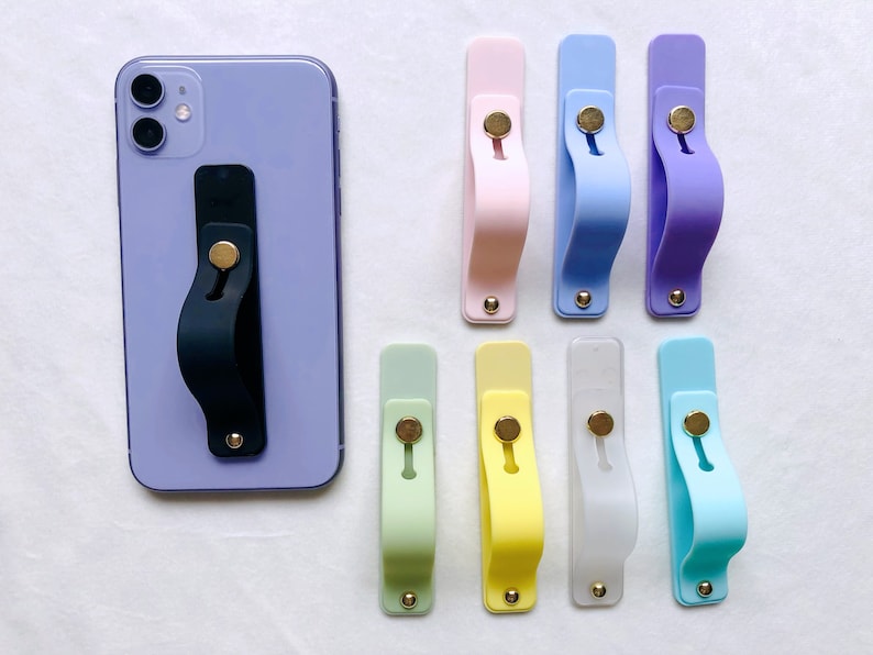 May include: A set of ten phone grips in various colors, including light blue, pink, yellow, green, and white. Each grip has a small gold button in the center.