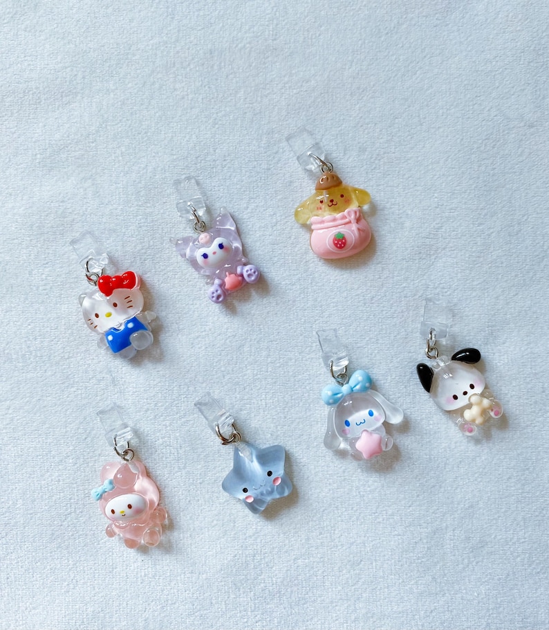 Pode incluir: Oito encantos de personagens coloridos com clipes de pl&aacute;stico transparente. Os encantos apresentam uma variedade de personagens, incluindo um gato, um cachorro, uma estrela e um coelho. Os encantos s&atilde;o perfeitos para adicionar um toque de personalidade &agrave;s suas chaves, bolsas ou outros acess&oacute;rios.