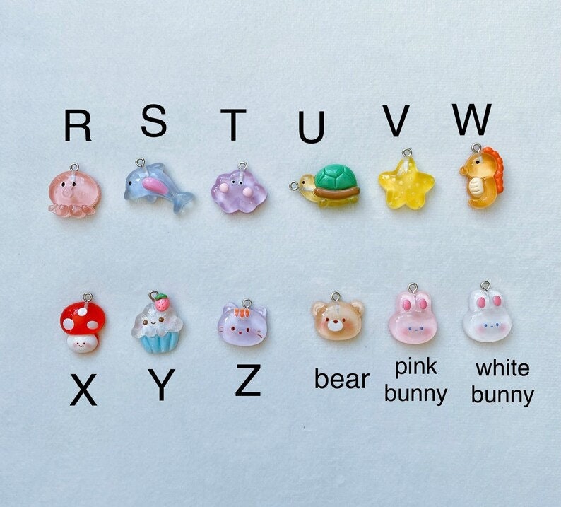 May include: A set of 16 colourful resin charms with letter and animal designs. The charms are labelled with letters from R to W and then X to Z, with the last three charms labelled "bear", "pink bunny", and "white bunny".