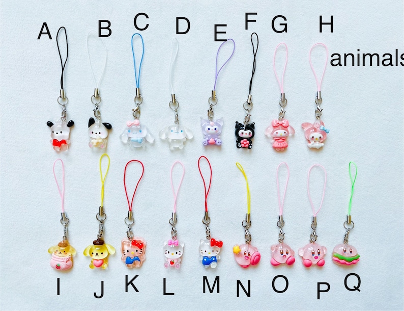 Pode incluir: Um conjunto de 16 pingentes coloridos de personagens com cord&otilde;es de corda combinando. Os pingentes apresentam personagens de desenhos animados populares como Hello Kitty, My Melody e Keroppi. Os cord&otilde;es s&atilde;o de v&aacute;rias cores, incluindo rosa, azul, vermelho, amarelo e verde. Os pingentes s&atilde;o etiquetados com as letras A a Q.