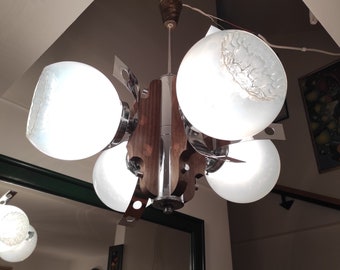 May include: A mid-century modern chandelier with a wood and chrome frame and five white frosted glass globes.