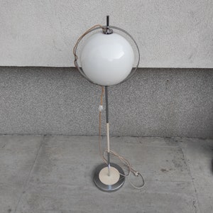 May include: A white globe lamp with a chrome frame and base. The lamp has a white cord and a white plug.