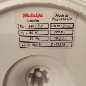 May include: A white label with black text that reads "Metalija Subotica" and "Made in Yugoslavia". The label also includes technical specifications for the product, such as "Tip: 260/Z-2", "Fab. br. 9759", "P1 = 50 W", "220 V-", "50 Hz", "1977", "ATEST RSO br.", and "Z-75275".