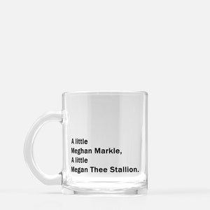 May include: A clear glass mug with a black handle. The mug has text that reads "A little Meghan Markle, A little Megan Thee Stallion."