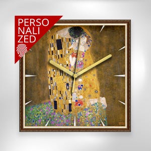 Puede incluir: Reloj de pared cuadrado con la obra "El Beso" de Gustav Klimt. El reloj tiene un marco de madera marrón, manecillas doradas y marcadores blancos. En la esquina superior izquierda hay una pancarta roja que dice "PERSONALIZADO".