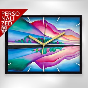 Op de afbeelding: Een rechthoekige wandklok met een zwart frame. De wijzerplaat toont een kleurrijk abstract landschapsschilderij in tinten blauw, groen, roze en paars. Goudkleurige wijzers geven de tijd aan. Het woord "PERSONALIZED" staat in de linkerbovenhoek.