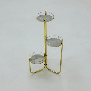 Vintage Flower stand made of brass-colored metal with three marble shelves 1970s