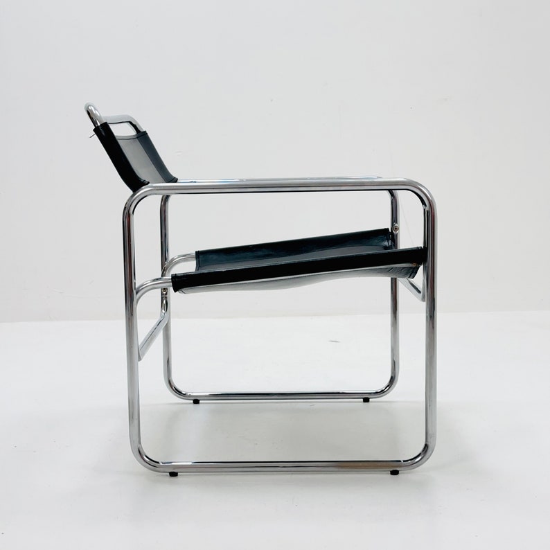 May include: A chrome and black leather lounge chair with a simple, minimalist design.