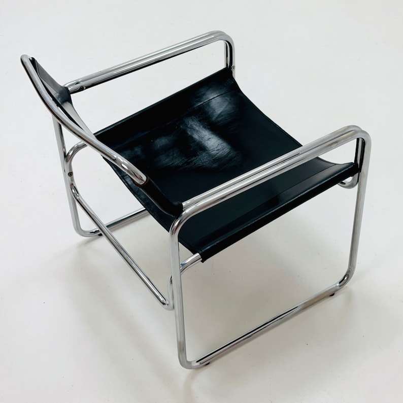 May include: A black leather chair with a chrome frame. The chair has a simple, modern design.