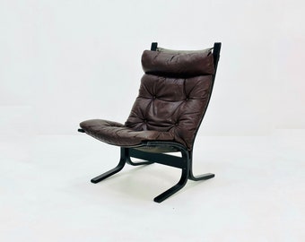 May include: A brown leather armchair with a black wooden frame. The chair has a tufted back and seat.