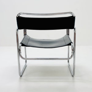 May include: A black leather chair with a chrome frame. The chair has a simple, modern design.