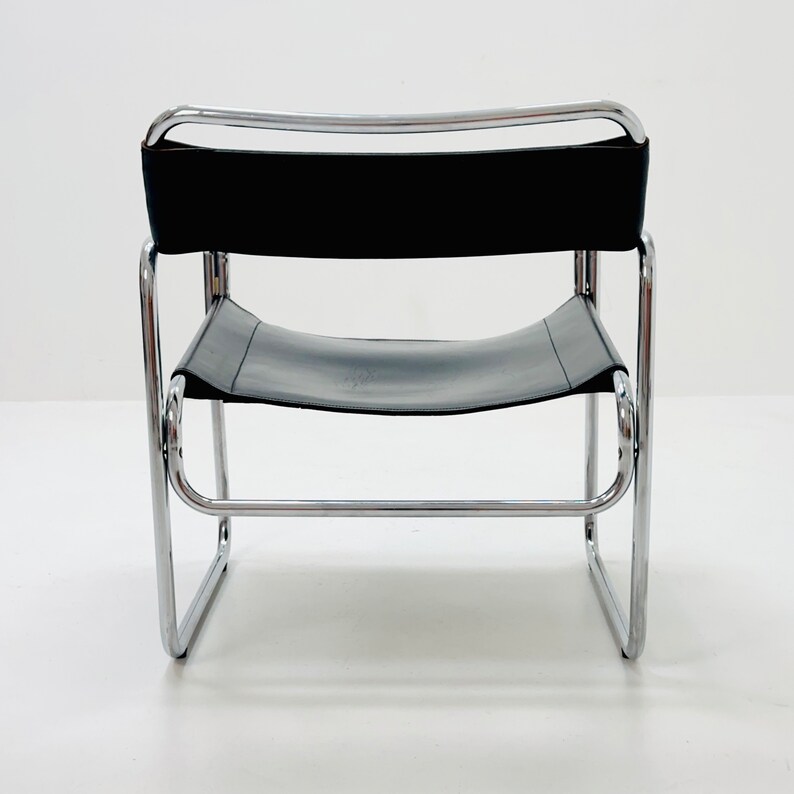 May include: A black leather chair with a chrome frame. The chair has a simple, modern design.