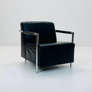 May include: A black leather armchair with chrome legs and arms. The chair has a simple, modern design.